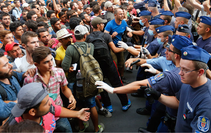 Поліція була змушена закрити вокзал через заворушення, мігрантів відтіснили на площу і не дозволяють їм пройти до потягів, незважаючи на наявність квитків   Співробітники поліції витісняють нелегальних іммігрантів за межі вокзалу Келети в Будапешті   Фото: Reuters   Москва